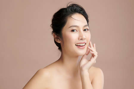 Beautiful young asian woman with clean fresh skin on beige background, Face care, Facial treatment, Cosmetology, beauty and spa, Asian women portrait.の写真素材