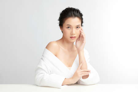 Beautiful young Asian woman wearing bathrobe on white background, Face care, Facial treatment, Cosmetology, beauty and spa Concept.の写真素材