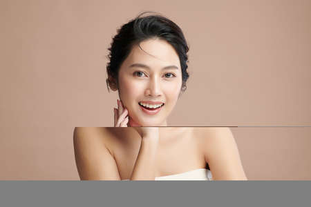 Beautiful young asian woman with clean fresh skin on beige background, Face care, Facial treatment, Cosmetology, beauty and spa, Asian women portrait.の写真素材