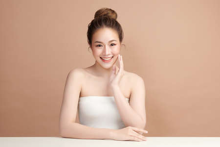 Beautiful young asian woman with clean fresh skin on beige background, Face care, Facial treatment, Cosmetology, beauty and spa, Asian women portrait.の写真素材