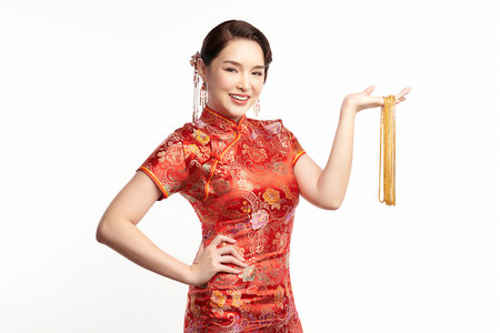 Chinese new year festival, Beautiful Young asian woman wearing traditional cheongsam qipao dress with gold necklaces on white background,の写真素材