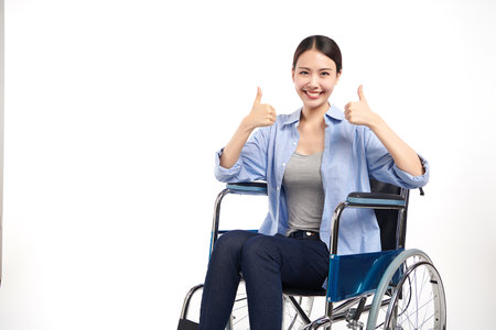 Beautiful young asian women with happy smiling sitting in a wheelchair on white background, healthcare concept, accident, insurance, life insurance, wellness, hospital.の写真素材