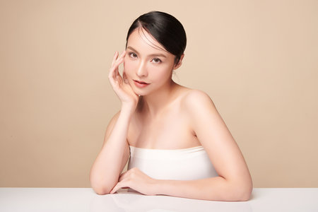 Beautiful young asian woman with clean fresh skin on beige background, Face care, Facial treatment, Cosmetology, beauty and spa, Asian women portrait.の写真素材