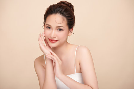 Beautiful young asian woman with clean fresh skin on beige background, Face care, Facial treatment, Cosmetology, beauty and spa, Asian women portrait.の写真素材