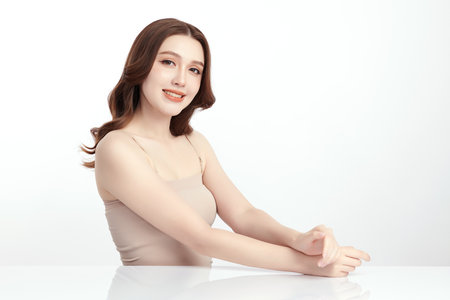 A beautiful young Asian woman with clean, fresh skin against a white background. Skincare, facial treatment, cosmetology, beauty, and spa. An elegant portrait of an Asian woman.の写真素材