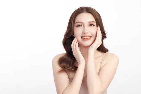 A beautiful young Asian woman with clean, fresh skin against a white background. Skincare, facial treatment, cosmetology, beauty, and spa. An elegant portrait of an Asian woman.の写真素材