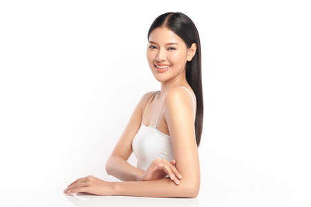 A beautiful young Asian woman with clean, fresh skin against a white background. Skincare, facial treatment, cosmetology, beauty, and spa. An elegant portrait of an Asian woman.の写真素材