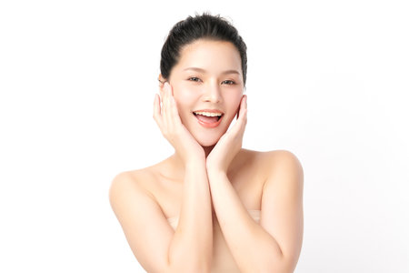 A beautiful young Asian woman with clean, fresh skin against a white background. Skincare, facial treatment, cosmetology, beauty, and spa. An elegant portrait of an Asian woman.の写真素材