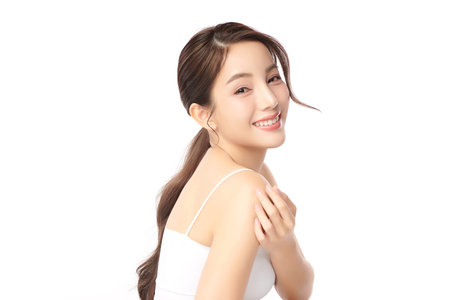 A beautiful young Asian woman with clean, fresh skin against a white background. Skincare, facial treatment, cosmetology, beauty, and spa. An elegant portrait of an Asian woman.の写真素材