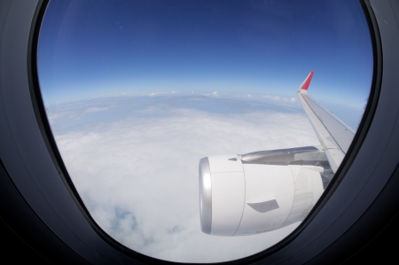 Clouds and sky as seen through window of an aircraftの写真素材