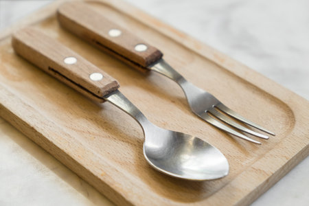 Cutlery for dessert on wooden plate