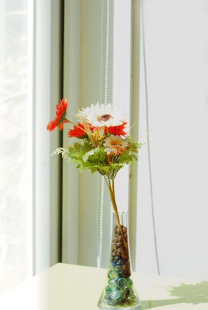 Cloth flower in glass jug on morning shine day.の写真素材