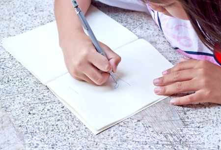 Child girl drawing in note book.の写真素材