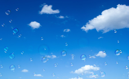 Soap suds fly on blue sky background.の写真素材