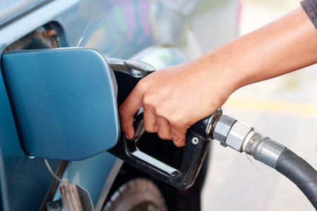 Pumping gas to the car at gas station.