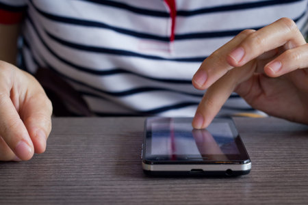 hands touching smartphone bright background, closeup