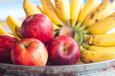 Red apples on plate with banana.の写真素材