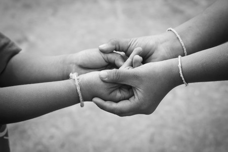 Poor childrens holding a little boy hands.の写真素材