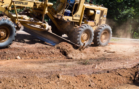 Nongkhai, Thailand - June 30: The Motorgrader is grading of rural road construction between Ampher Phonphisia to Ampher Pak Kad in Nongkhai, Thailand on June 30, 2015.のeditorial素材