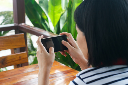 Hands touching smartphone bright background, closeupの写真素材