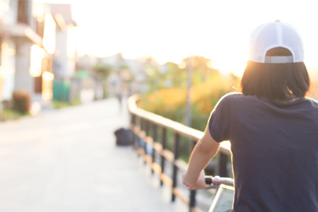 Defocused Woman with bicycle in the city.Blurred motion activity in sunset background.の写真素材
