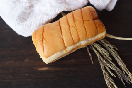 Tasty bun on dark wooden board.