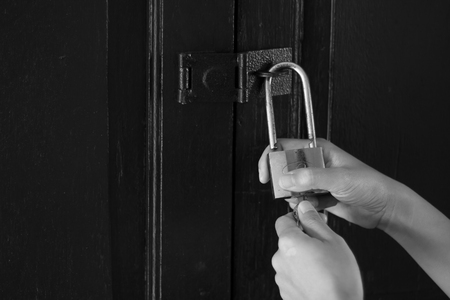 Women hand holding key with closed doors.の写真素材
