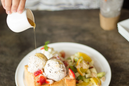 selective focus of honey toast  with fruit and icecream on poor lighting.の写真素材
