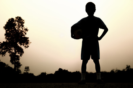 Silhouettes of Asian boy is playing soccer.の写真素材