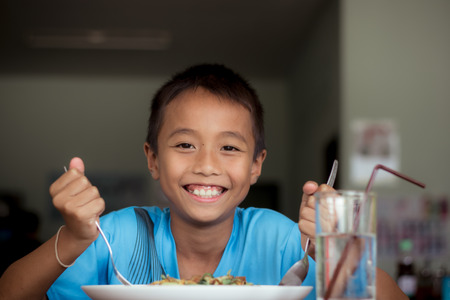 Asian children boy eating healthy food in canteen or cafeteria.の写真素材