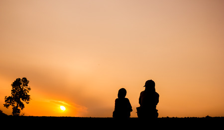 Silhouette of people are viewing beautiful sunset.の写真素材