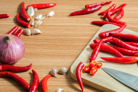 Garlic, peppers and onions on a wooden floor.の写真素材