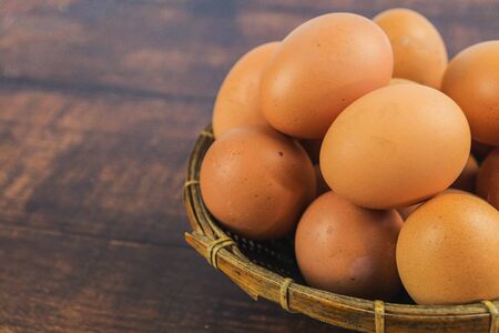 Eggs in the basket On brown wood floorの写真素材