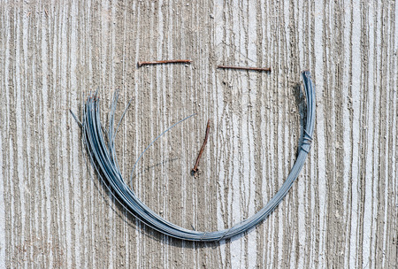 steel wire  with nail smile face on cementの写真素材