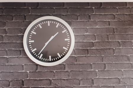 Analog clock on brick wallの写真素材