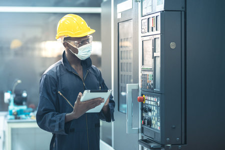 The egineer in the industial working with pad computer control the machine
