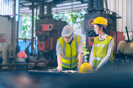 The chief engineer safty white helmet and engineer yellow safety helmet seriously planning solution of project engineering in the industialの写真素材