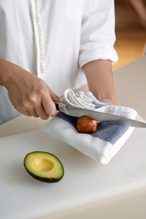 Hand using knife to get rid off avocado seed