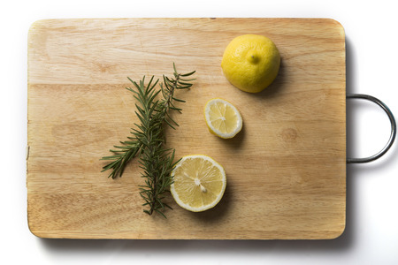 Rosemary and lemon on chopping blockの写真素材