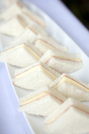 Ham cheese sandwiches on white plates in partyの写真素材