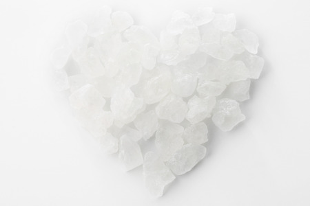 Crystalline sugar group in heart shape on tableの写真素材