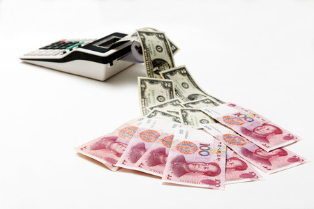 China hundred bills and American two dollar bills come out from calculatorの写真素材