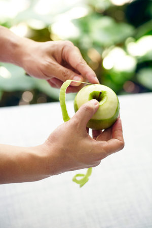 Hand using knife peeling apple skinの写真素材