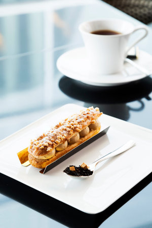 French dessert Eclair in plate on table