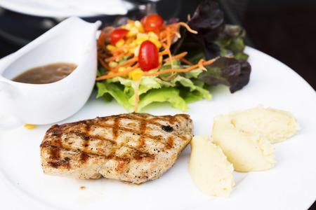 Chicken steak with mash potato and salad on plateの写真素材