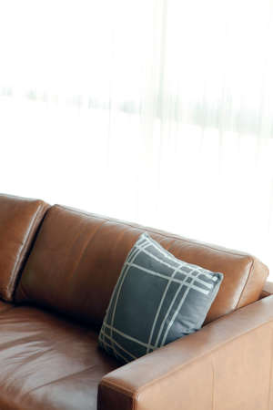 Blue pillow on brown leather sofaの写真素材