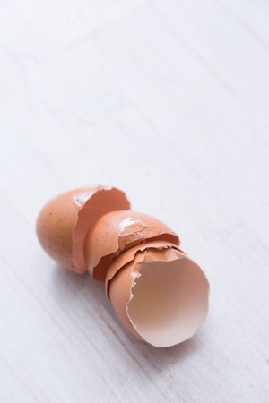 Cracked eggs stacked on white table