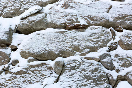 Snow covered rock wall in winterの写真素材