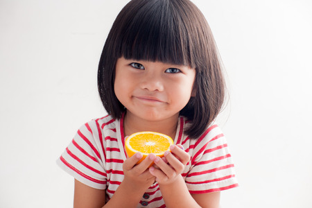 little girl holding orangeの写真素材