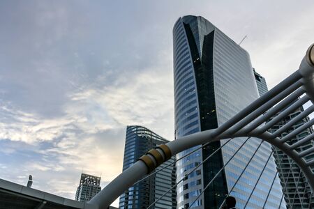 People walking at Chong Nonsi skywalk in the evening to go Home,with high buildingtransportation in heart of Bangkok, Thailandの写真素材